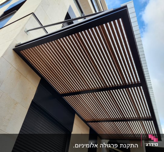 פרגולה מאלומיניום עם קורות אופקיות על קיר בניין